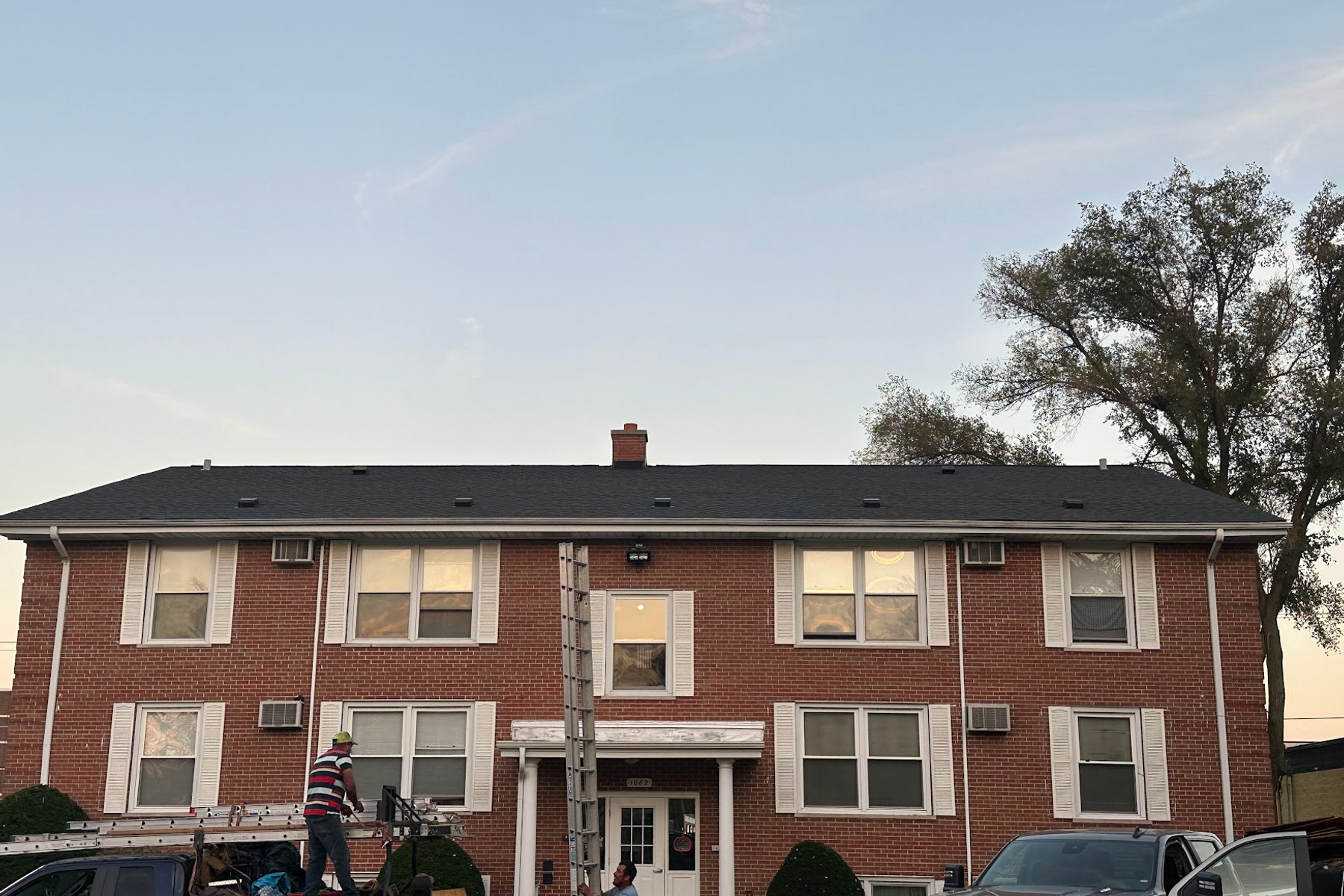 Abel crew finishing a roof on a brick apartment building